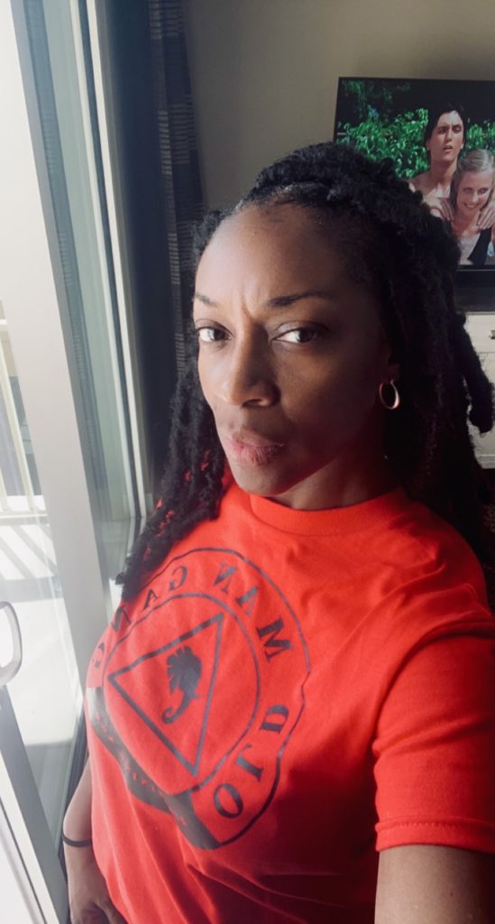 A woman with dreads in an orange shirt.