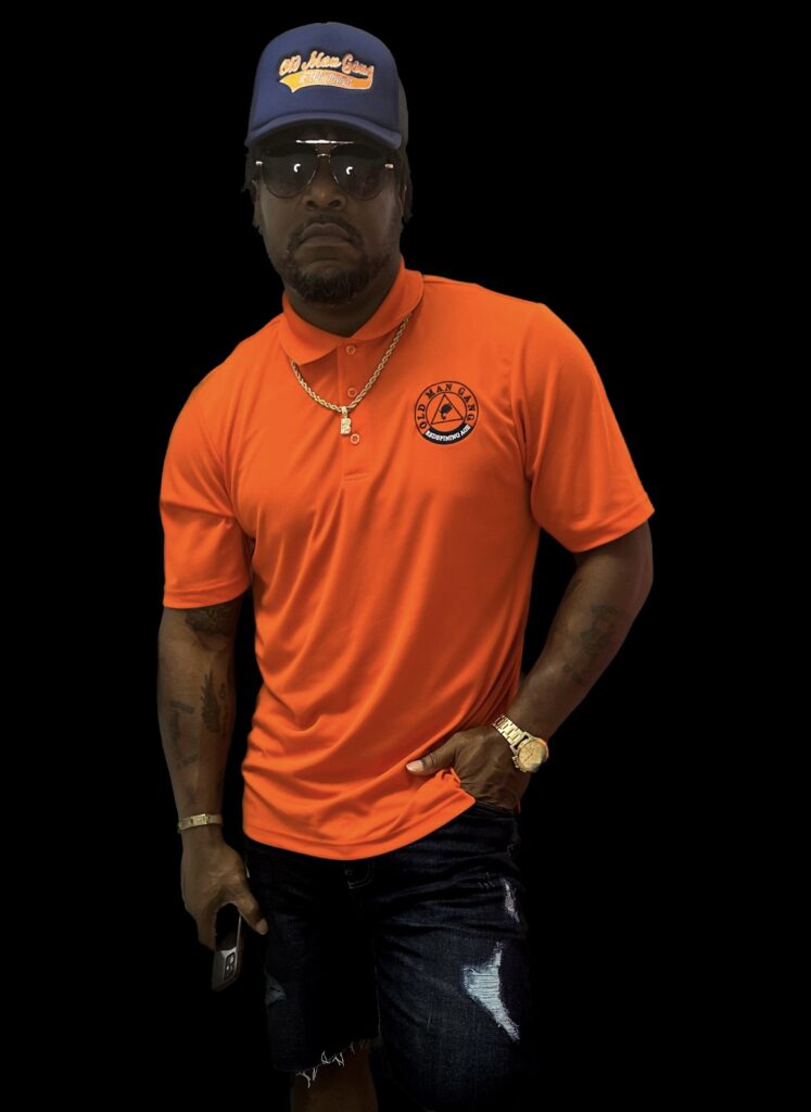 A man in an orange shirt and jeans.